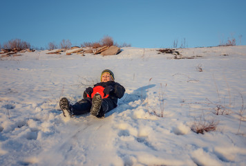 Fototapeta na wymiar Happy little boy having fun in winter snow