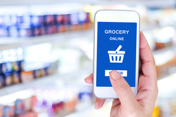 Hand holding smart phone with grocery shopping online on screen