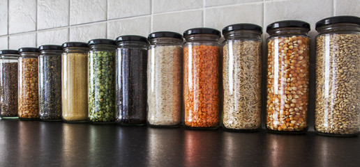 Health Food - herbs, seeds and pulses in spice jars.
