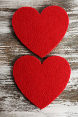 Red felt hearts on grey wooden background