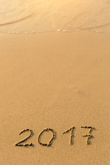 2017 - inscription on sand beach with the soft wave.