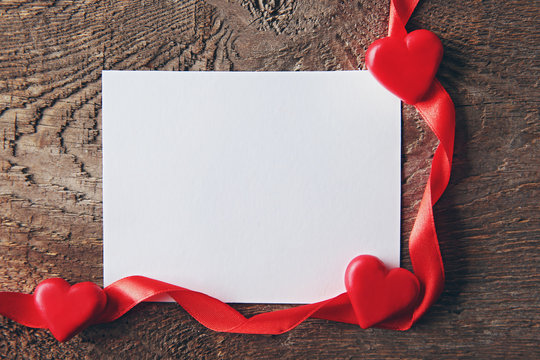 Blank present Valentine card on wooden background