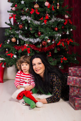 Beauty mom and son sitting near Xmas tree