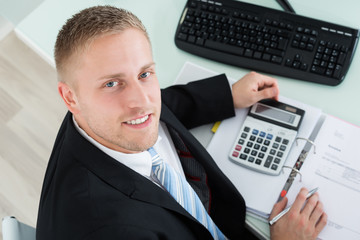 Happy Businessman Calculating Invoice