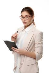 Young stylish woman standing holding a notepad and a pen.