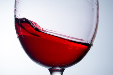 red wine in glass, splashing, splash, wave of red wine close up
