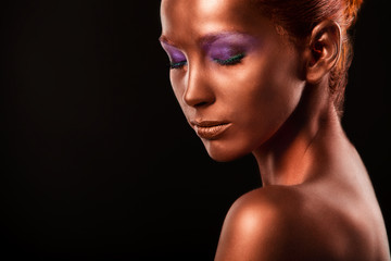 Fototapeta premium Gilt. Golden Woman's Face Closeup. Futuristic Gilded Make-up. Painted Skin bronze.
