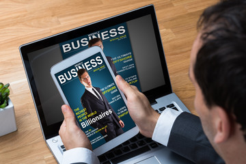 Businessman Reading Business Magazine On Tablet