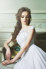 Beautiful Young Bride Sensualy Posing On Sofa. White Wedding Dre