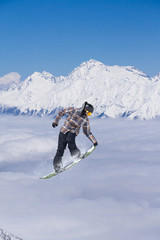 Flying snowboarder on mountains. Extreme sport.