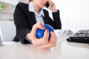 Businesswoman Pressing Stressball At Desk