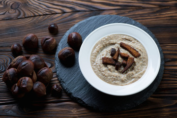 Chestnut cream-soup with croutons in a rustic wooden setting