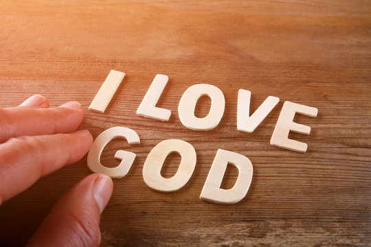 man hand spelling the word i love god from wooden letters, retro style image
