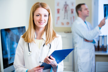 Portrait of friendly confident doctors in hospital. Enthusiastic medical staff at work. Female doctor with stethoscope looking at the camera. 