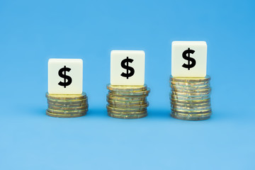 Symbol $$$ on stacks of gold coins over blue background