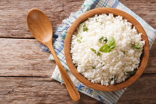 Cauliflower rice with basil in a bowl close-up. Horizontal top view

