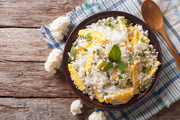 Cauliflower rice with scrambled eggs and herbs. horizontal top view
