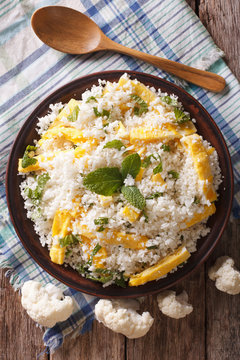 Cauliflower rice with scrambled eggs and herbs closeup. vertical top view
