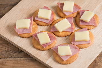 A snack of Crackers with ham, cheese. Selective focus.