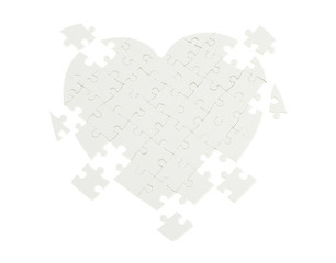 Incomplete jigsaw puzzle in a shape of a heart isolated on white