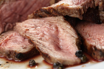 sliced beef steak on white plate close up