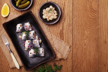 Rolled herring in vinegar, served with onions and pickles.