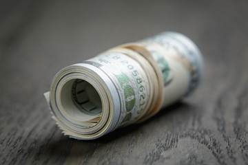 roll of new style hundred dollar bills on table