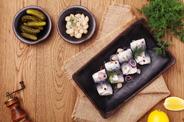 Rolled herring in vinegar, served with onions and pickles.