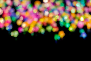 blured bokeh from colorful star paper on black background