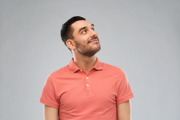 smiling man looking up over gray background