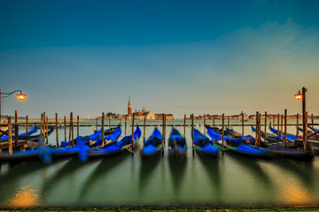 Gondolas in Venice - sunset with San Giorgio Maggiore church. San Marco, Venice, Italy