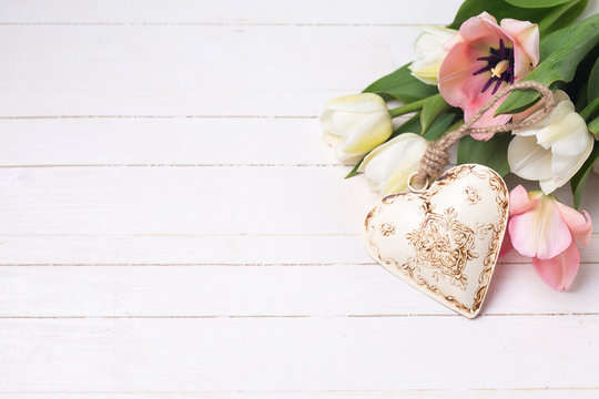White and pink tulips flowers and decorative heart on white  pai