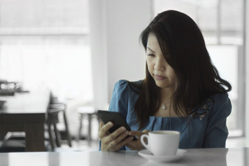 Asian female beautiful women portraits look smart phone, chinese girl relax life style in the cafe