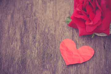 Fototapeta premium paper heart with artificial rose on wooden plank, vintage
