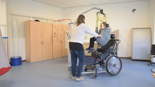 Disability a disabled child being cared for by a carer / Disability a disabled child being cared for by a special needs carer using specialist lifting equipment