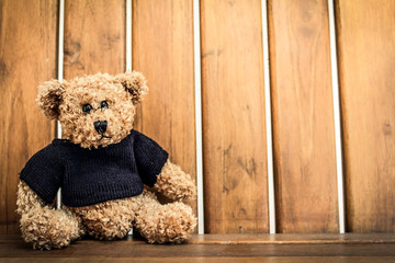 lonely teddy bear sit on wooden chair