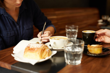 Two people having coffee and pastry at a cafe