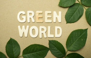 green world word and green leaves on brown craft paper for natural concept background

