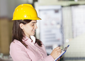 Mechanical engineer taking notes at metallurgy factory