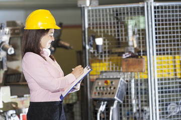 Mechanical engineer taking notes at metallurgy factory
