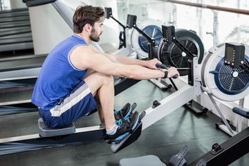 Handsome man doing exercise on drawing machine © WavebreakMediaMicro