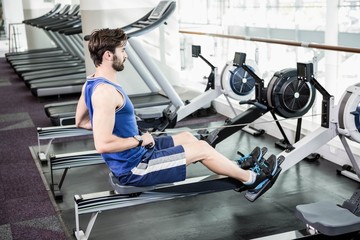 Handsome man doing exercise on drawing machine © WavebreakMediaMicro