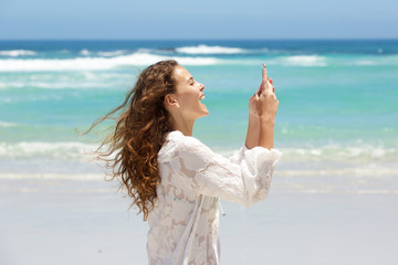Fototapeta na wymiar Young woman taking selfie at the beach