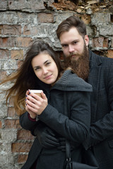 Fashion portrait of young couple drinking coffee in autumn outdo