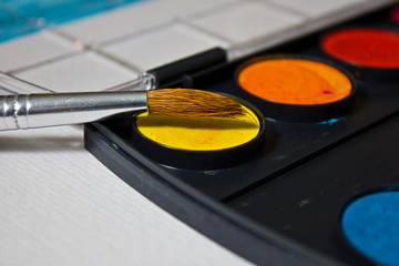 Still life with a set of watercolor painting. Paints, brushes and album with watercolor paper.