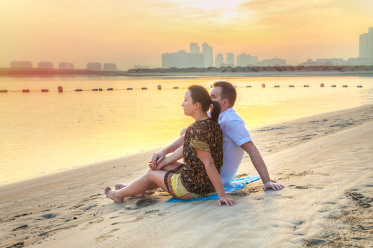 Couple Watching Romantic Sunrise On The Beach Of Abu Dhabi