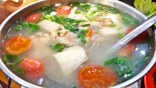 Serving of spicy fish soup Thai style in a hot pot
