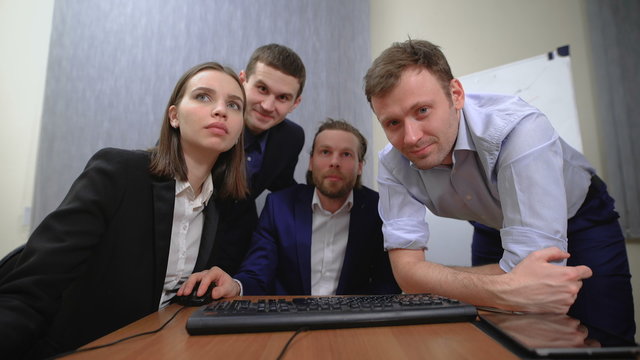The team of young businesspeople. They work together with the documents and figures. In the office. 