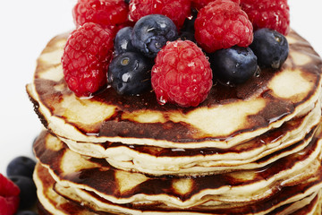 Fruit topped pancakes with honey, close up