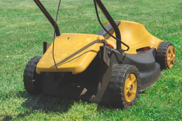 Fototapeta premium Lawn mover on a green grass field.